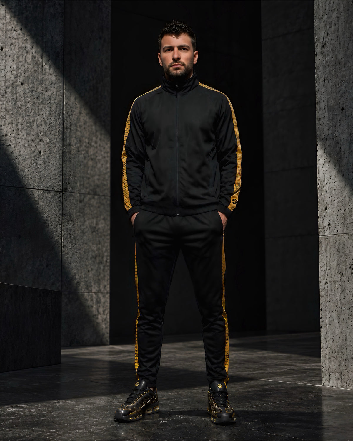 Men’s black and gold Calibra tracksuit by LGLGFG Apparel, featuring a zip jacket and matching joggers with patterned gold side stripes.