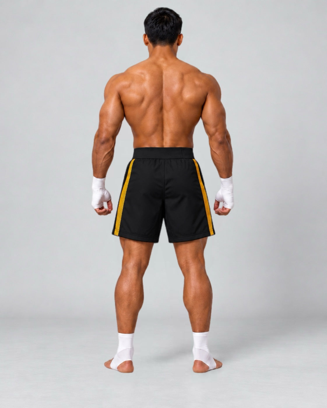 LGLGFG Calibra MMA combat shorts in black and gold, model rear view