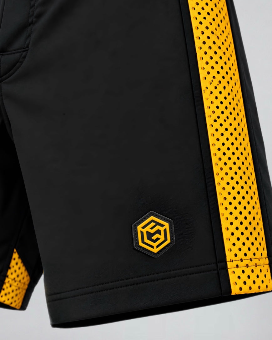 Close-up of black Calibra shorts with a gold perforated side panel and gold hex logo