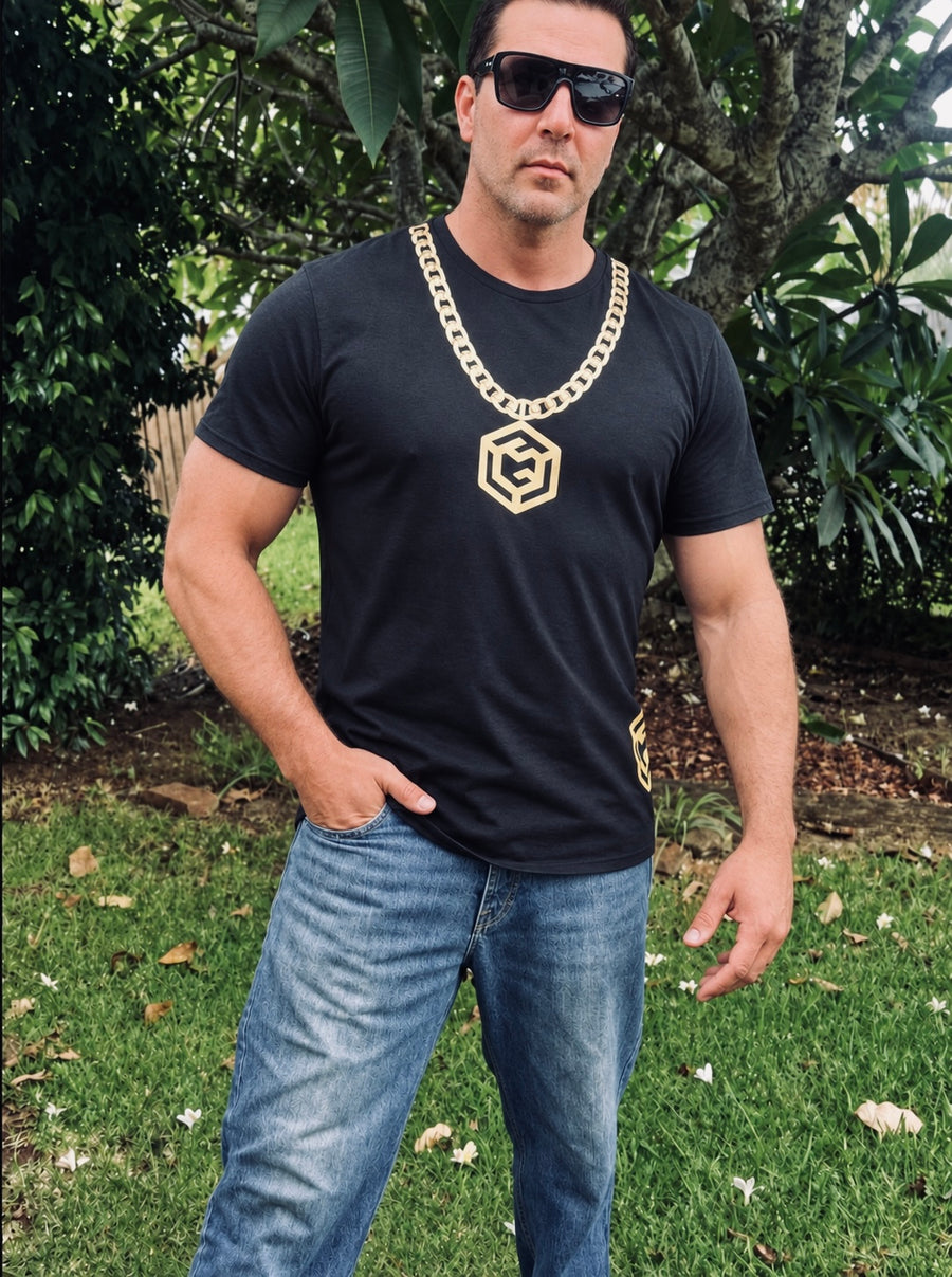 Man wearing a black LGLGFG T-shirt with a gold chest design outdoors